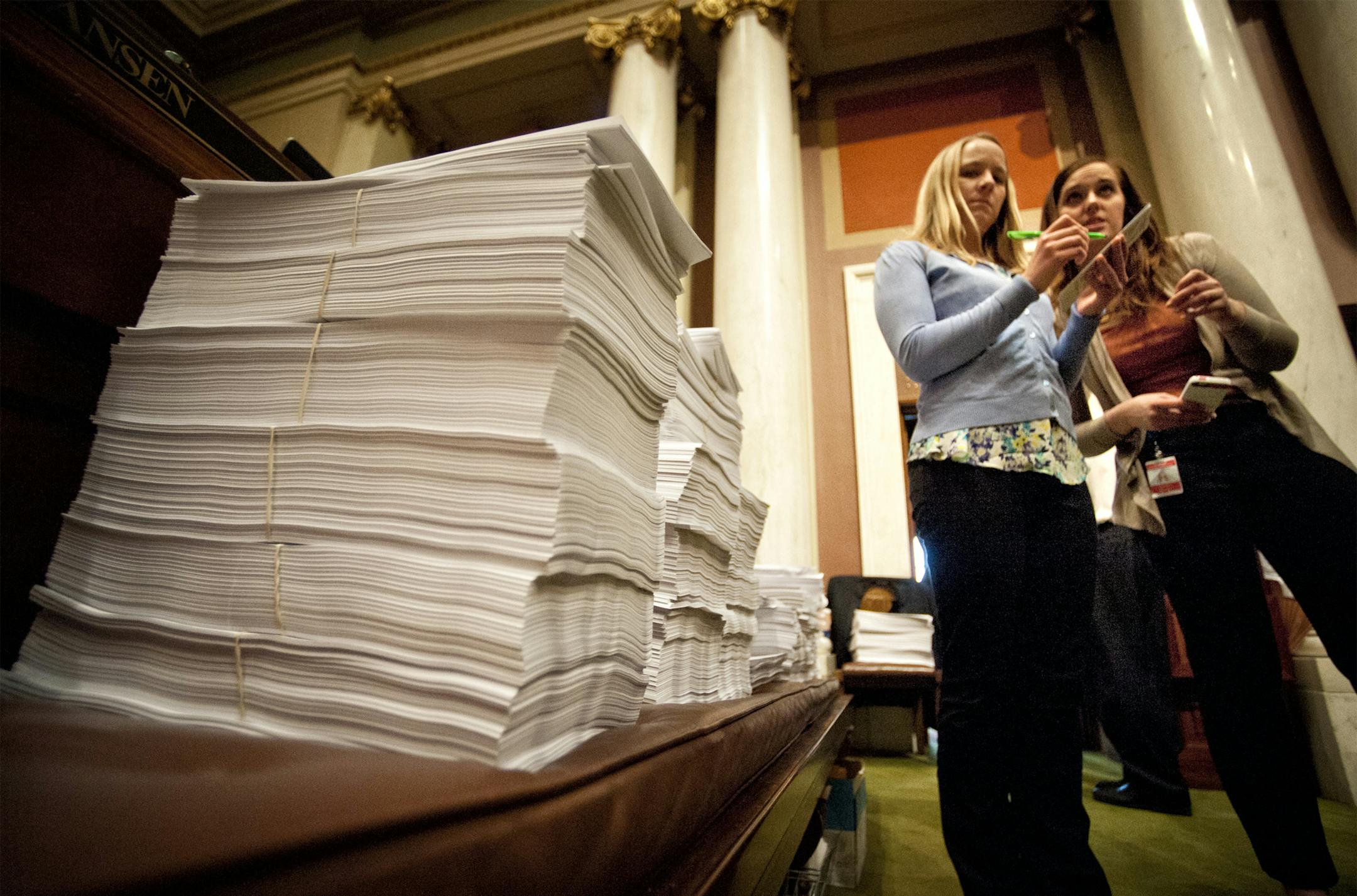 Stacks of printed bills and amendments at the start of Saturday's debate. With only 3 days left in the legislative schedule the House was set to debate a list of bills including childcare unionization Saturday, May 18, 2013 On the right DFL staffers Sasha Bergman and Jessica Nyman prepared for the start of the session. ] GLEN STUBBE * gstubbe@startribune.com