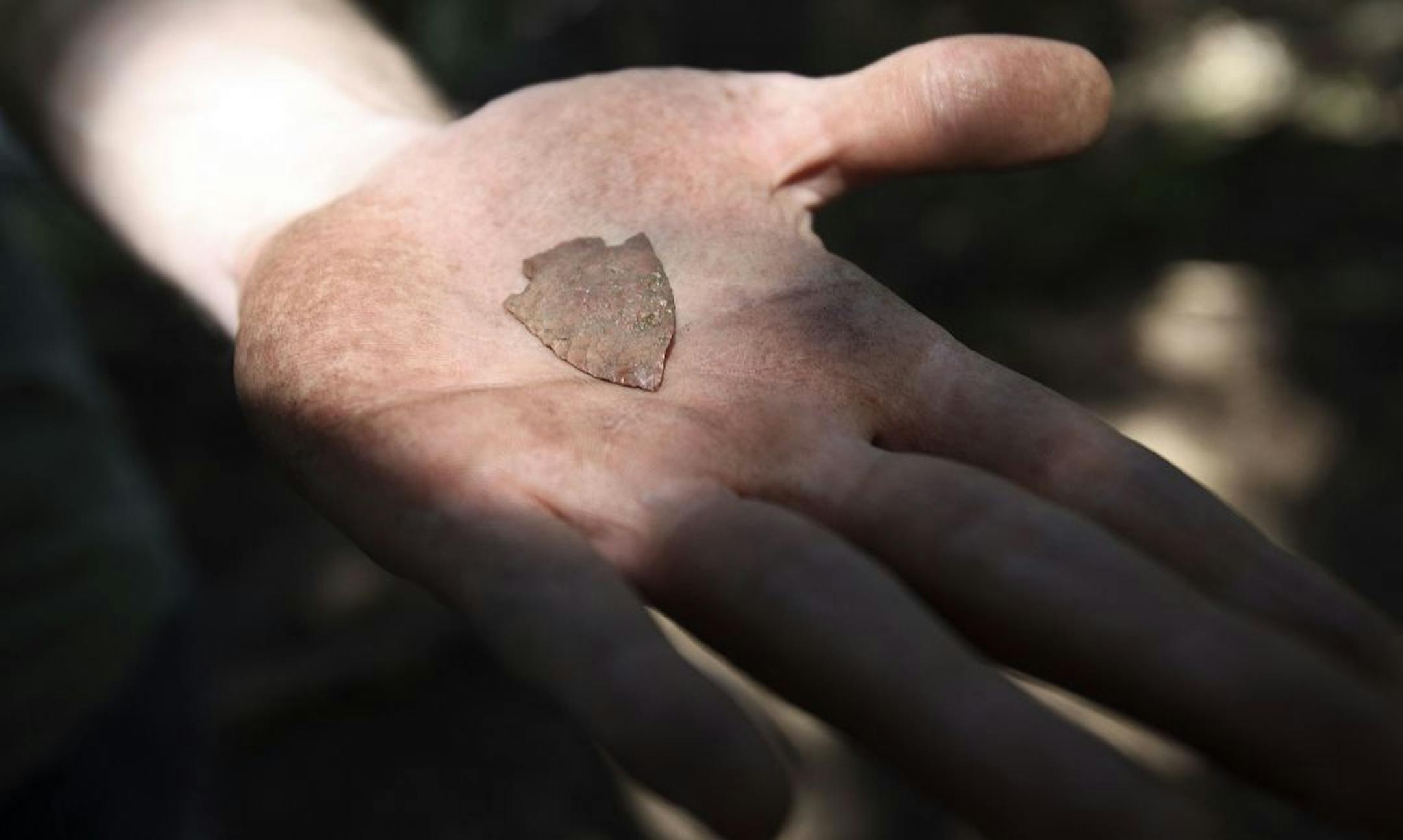 University of Minnesota anthropology student Gregory Reinert (cq) held a carved projectile that he found at an archaeological dig along Spring Lake near Hastings , Minn., Tuesday, July 26, 2011.