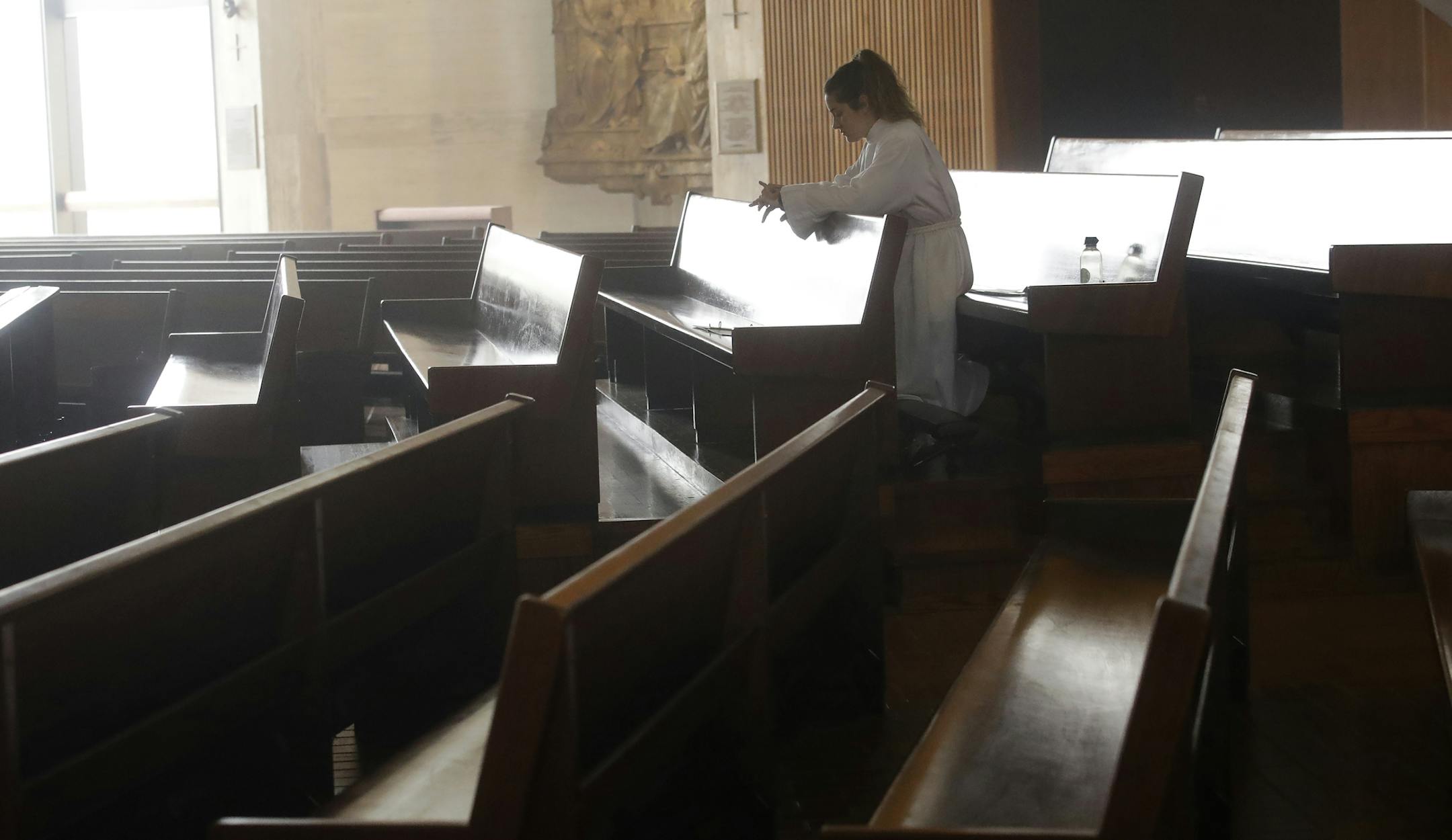 A choir member celebrates Easter Mass, which was live streamed, at a nearly empty St. Mary's Cathedral in San Francisco, Sunday, April 12, 2020. Christians around the world are celebrating Easter at a distance, with many churches closed and family gatherings canceled amid wide-ranging shutdowns due to the coronavirus pandemic. (AP Photo/Jeff Chiu)