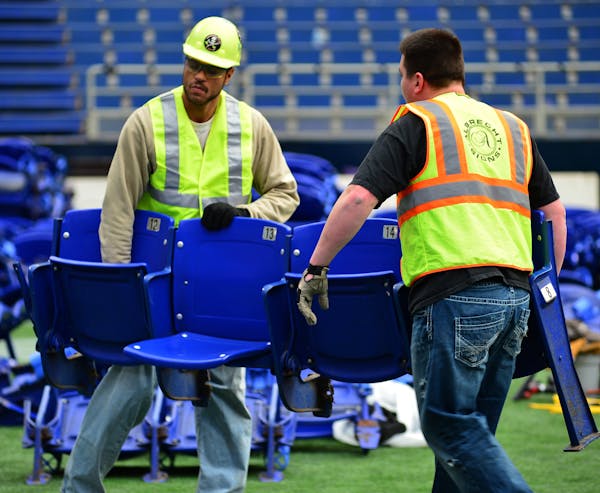 Albrecht Signs workers are removing seats at the Metrodome.