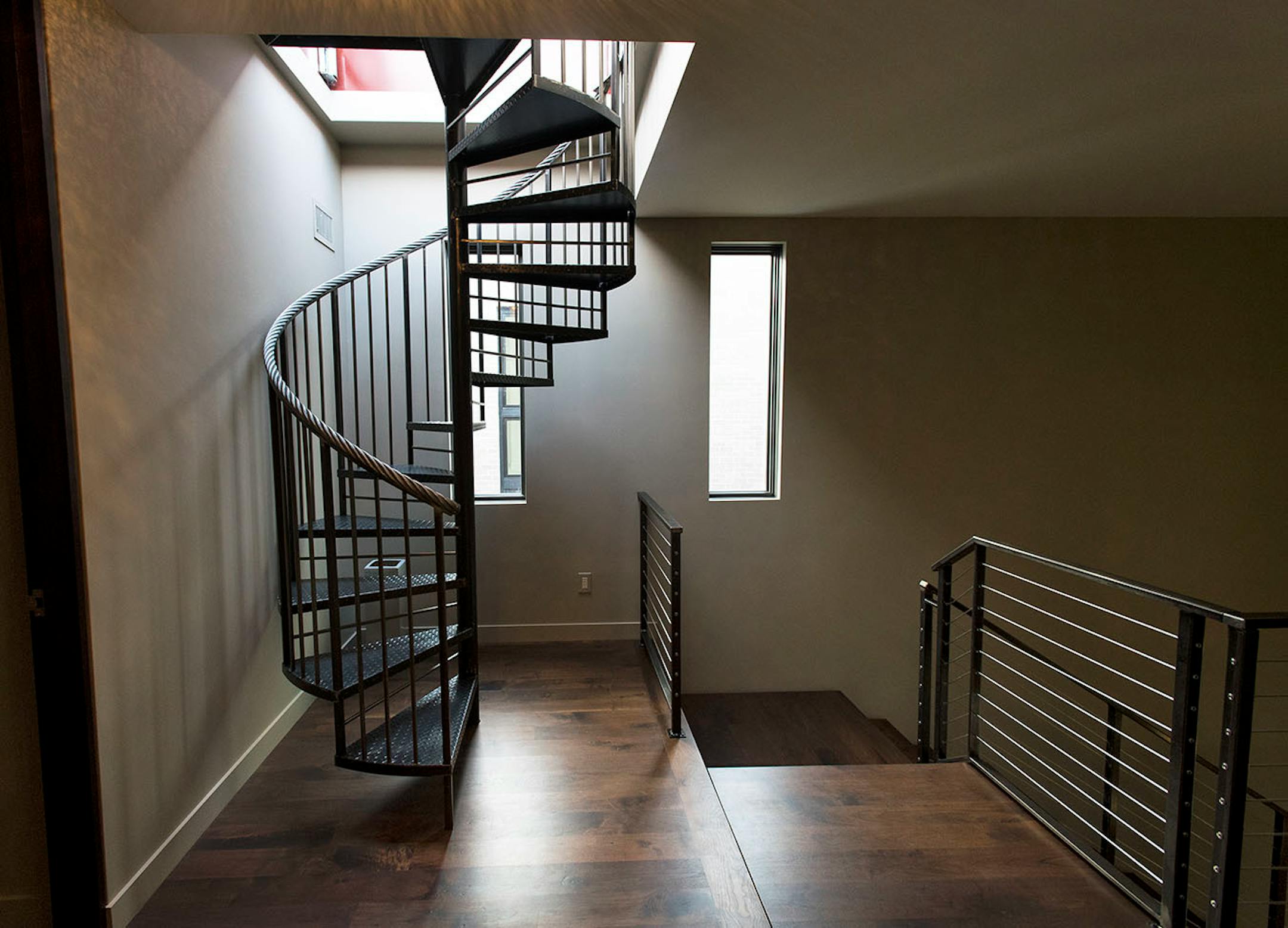 The spiral steel staircase leading to a rooftop patio.