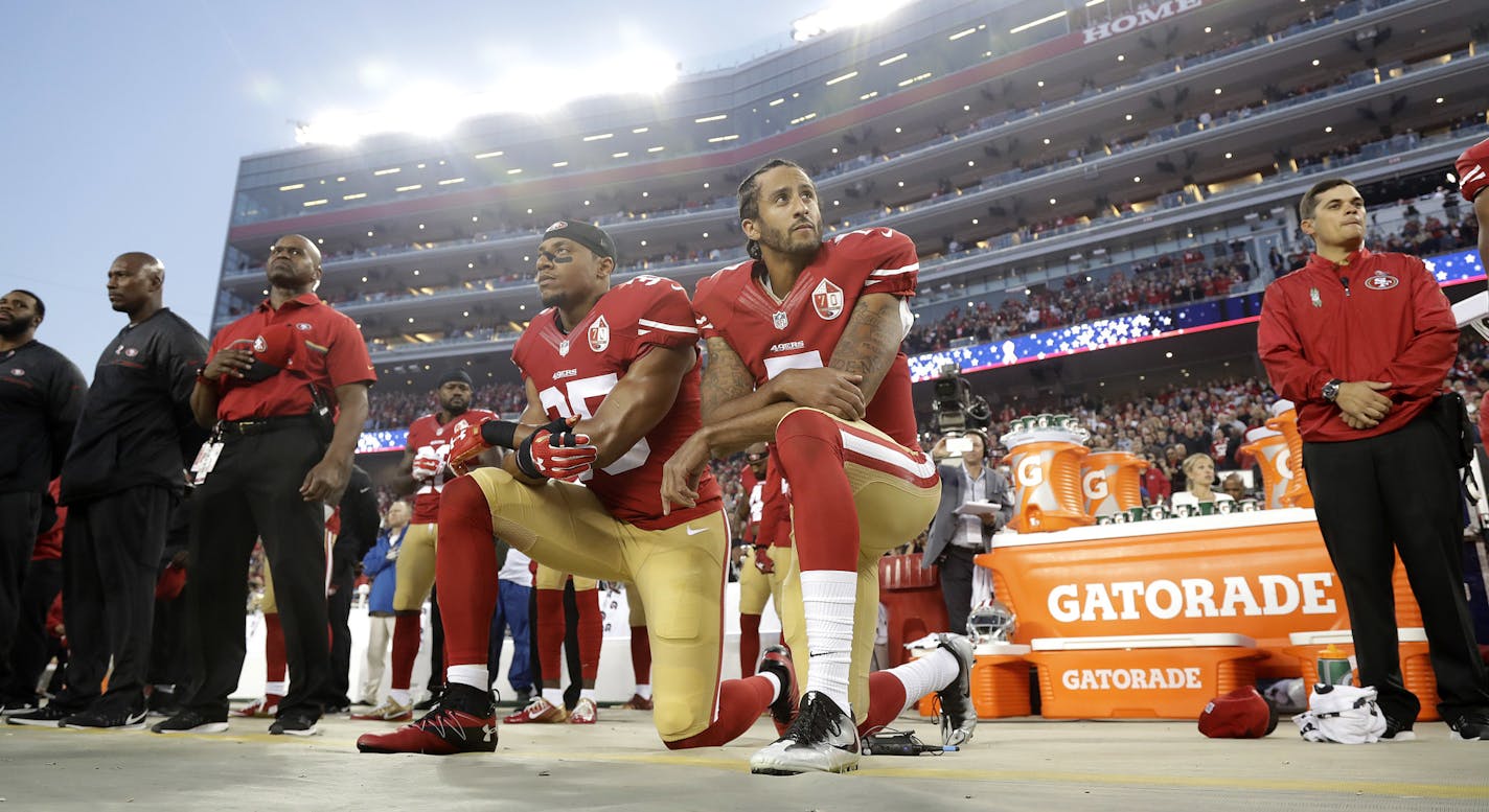 FILE - In this Sept. 12, 2016, file photo, San Francisco 49ers safety Eric Reid (35) and quarterback Colin Kaepernick (7) kneel during the national anthem before an NFL football game against the Los Angeles Rams in Santa Clara, Calif. What began more than a year ago with a lone NFL quarterback protesting police brutality against minorities by kneeling silently during the national anthem before games has grown into a roar with hundreds of players sitting, kneeling, locking arms or remaining in lo