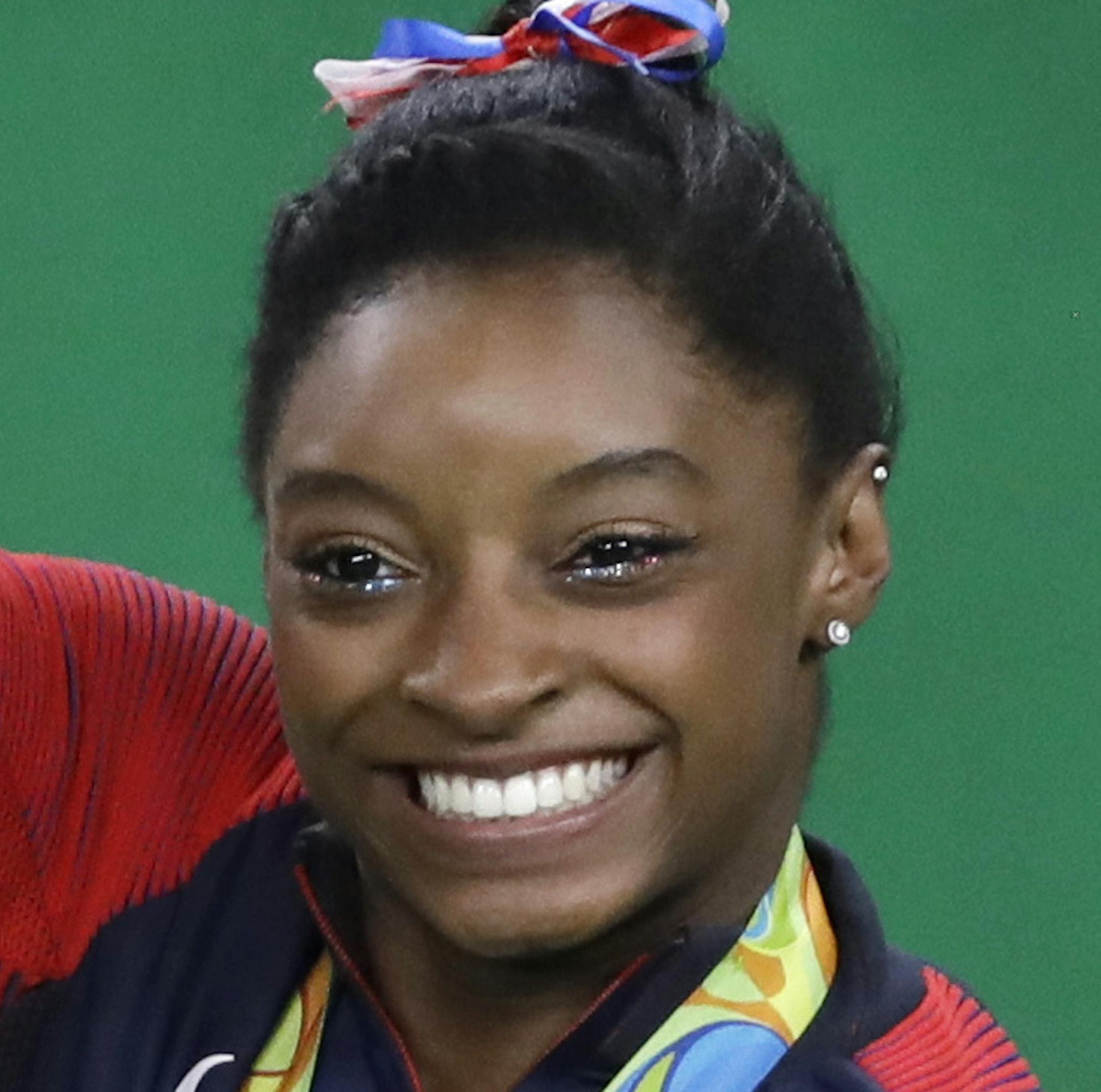 United States' Simone Biles waves to the audience during the medal ceremony for the artistic gymnastics women's team at the 2016 Summer Olympics in Rio de Janeiro, Brazil, Tuesday, Aug. 9, 2016. (AP Photo/Rebecca Blackwell)