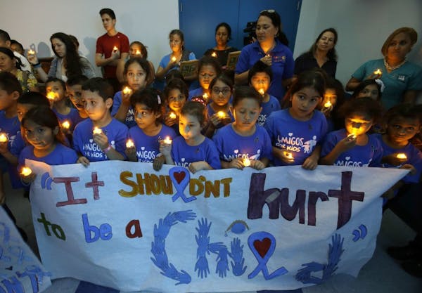 Children from an after school program participate in a candlelight vigil commemorating National Child Abuse Prevention Month at Jose Marti Park in Mia