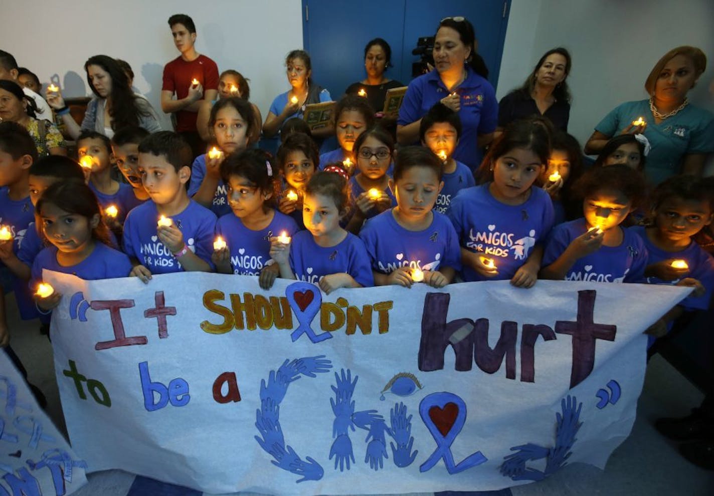 Children from an after school program participate in a candlelight vigil commemorating National Child Abuse Prevention Month at Jose Marti Park in Miami. Amigos For Kids, a nonprofit organization dedicated to preventing child abuse and neglect, held the event attended by about 200 kids and their families.