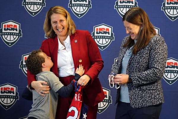 Minnesota Lynx head coach Cheryl Reeve gets a hug from her son Oliver with her wife Lynx vice president Carley Knox while holding her ceremonial jerse