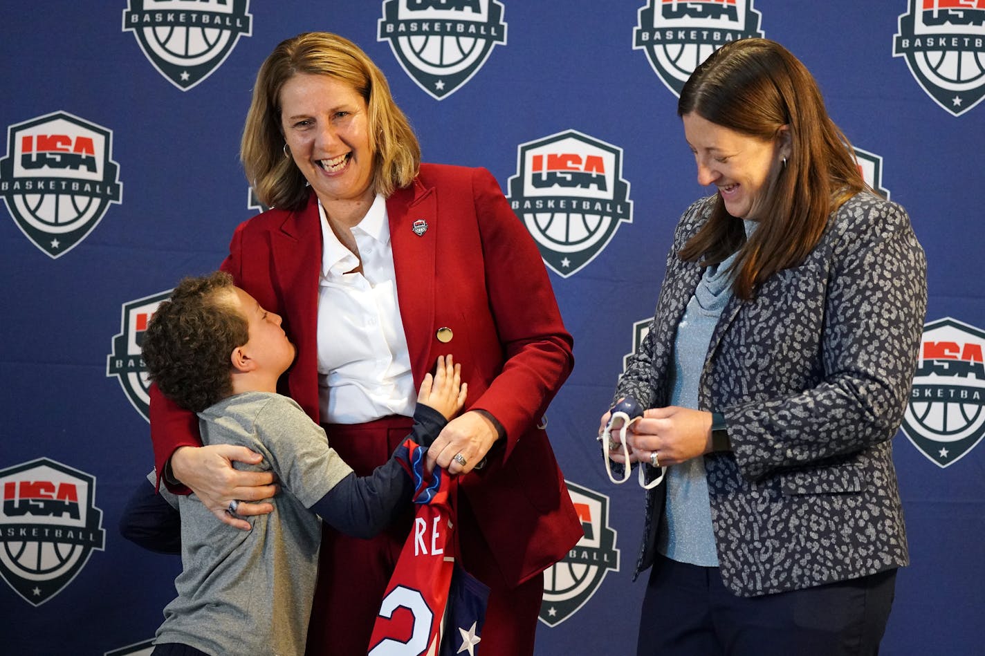 Minnesota Lynx head coach Cheryl Reeve gets a hug from her son Oliver with her wife Lynx vice president Carley Knox while holding her ceremonial jersey during a press conference to announce she'd been named the head coach of USA Women's Basketball Wednesday, Dec. 8, 2021 at the Target Center in Minneapolis. Reeve will head the USA team at the 2022 FIBA World Cup Qualifying Tournament, 2022 FIBA World Cup, the 2023-24 Olympic Qualifying Tournament and, if the United States qualifies, the 2024 Olympic Games. ] ANTHONY SOUFFLE • anthony.souffle@startribune.com