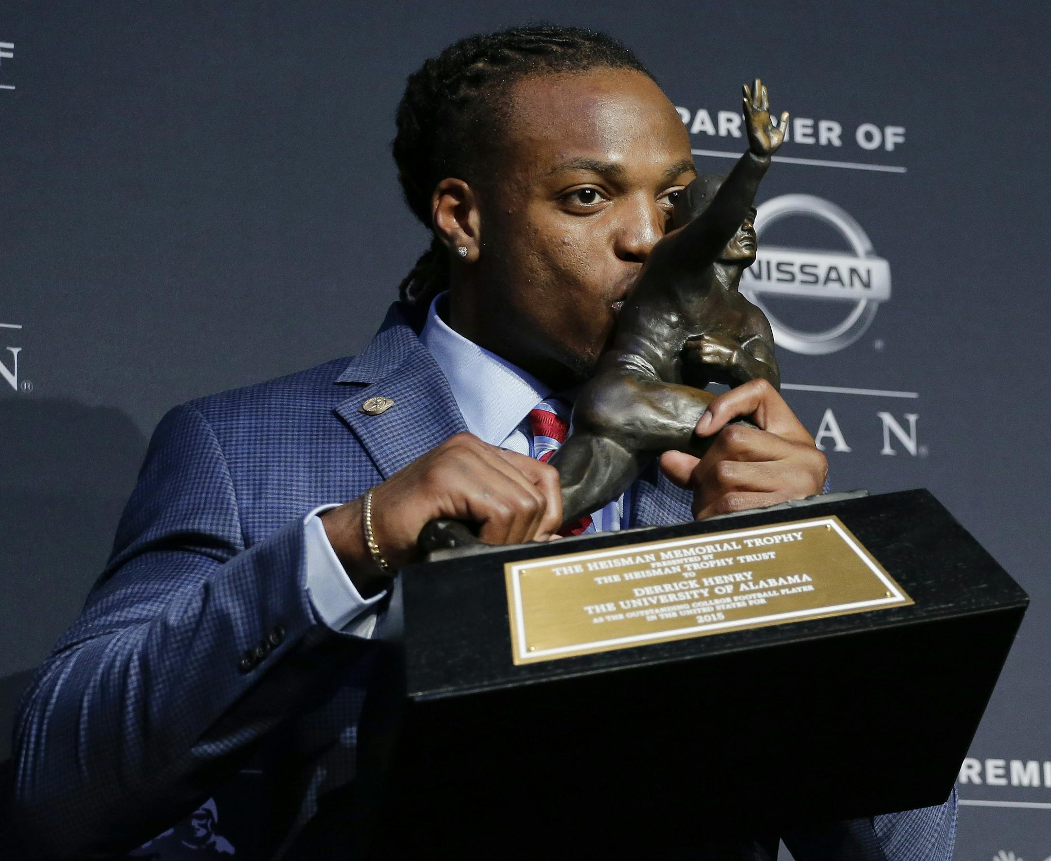 Alabama's Derrick Henry kisses the Heisman Trophy while posing for photos after winning the award as the country's top college football player, Saturday, Dec. 12, 2015, in New York. (AP Photo/Julie Jacobson)