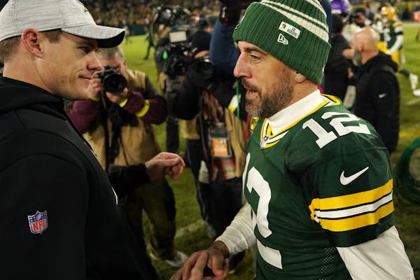 Minnesota Vikings head coach Kevin O'Connell greets Green Bay Packers quarterback Aaron Rodgers (12) on the field following an NFL game between the Mi