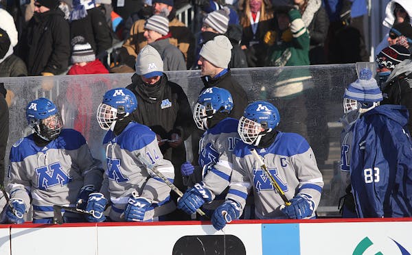 Minnetonka players on the bench, which was equipped with heaters, during the outdoor game on Jan. 19 in Bemidji.