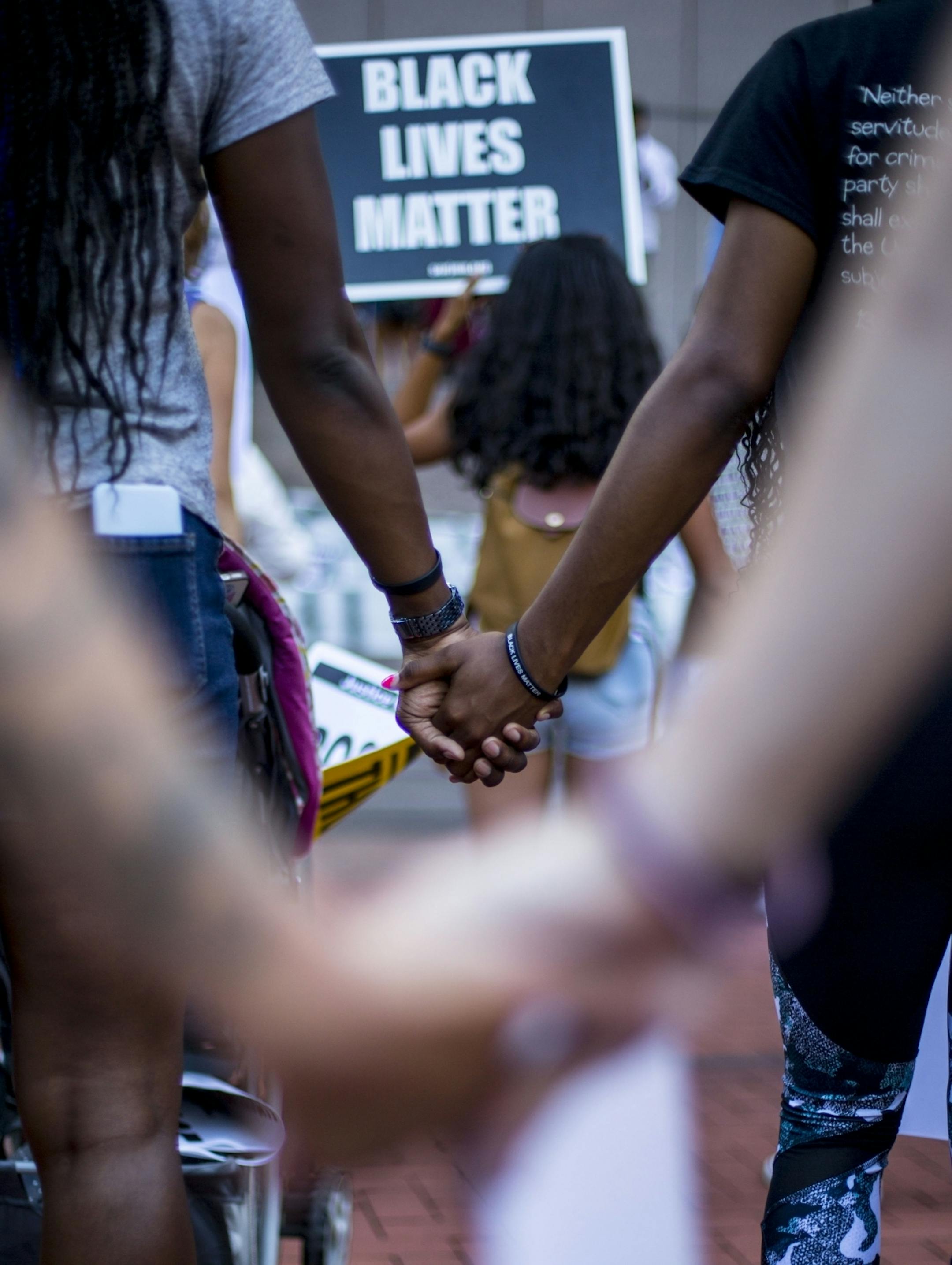 Protestors hold hands in prayer before they begin to march downtown.