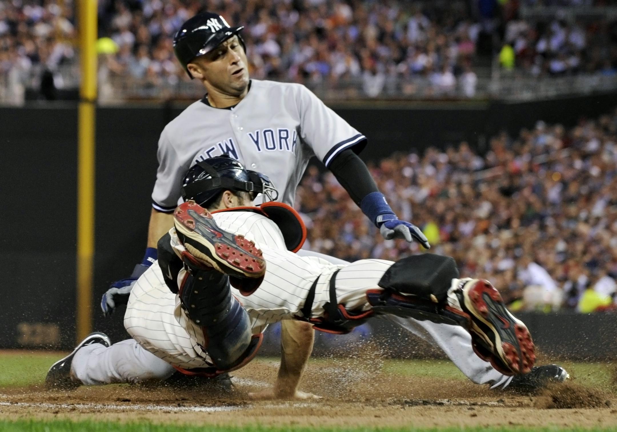 The Yankees ' Derek Jeter beat the tag by Twins catcher Joe Mauer to score from third on a sacrifice fly by Mark Teixeira during the fifth inning Friday.