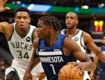 Timberwolves forward Anthony Edwards drives against Bucks forward Giannis Antetokounmpo during the first half