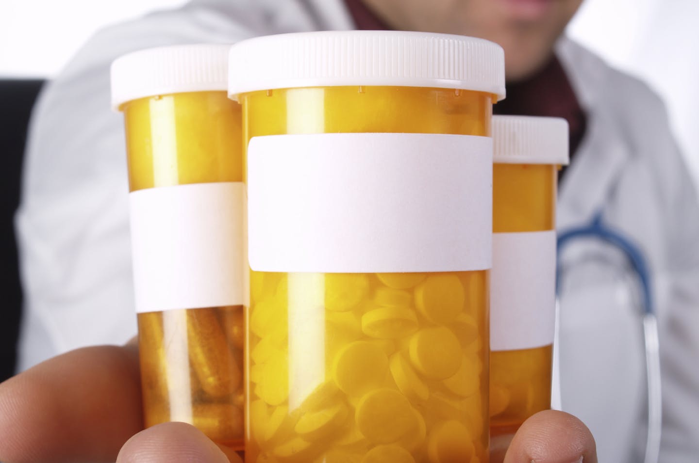 credit: Stephanie Horrocks, iStock Pharmacist holds bottles of pills.