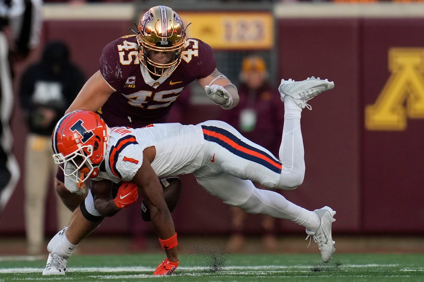 Illinois wide receiver Isaiah Williams (1) fumbles the football after catching a pass as Minnesota linebacker Cody Lindenberg (45) goes to tackle during the second half of an NCAA college football game Saturday, Nov. 4, 2023, in Minneapolis. (AP Photo/Abbie Parr)