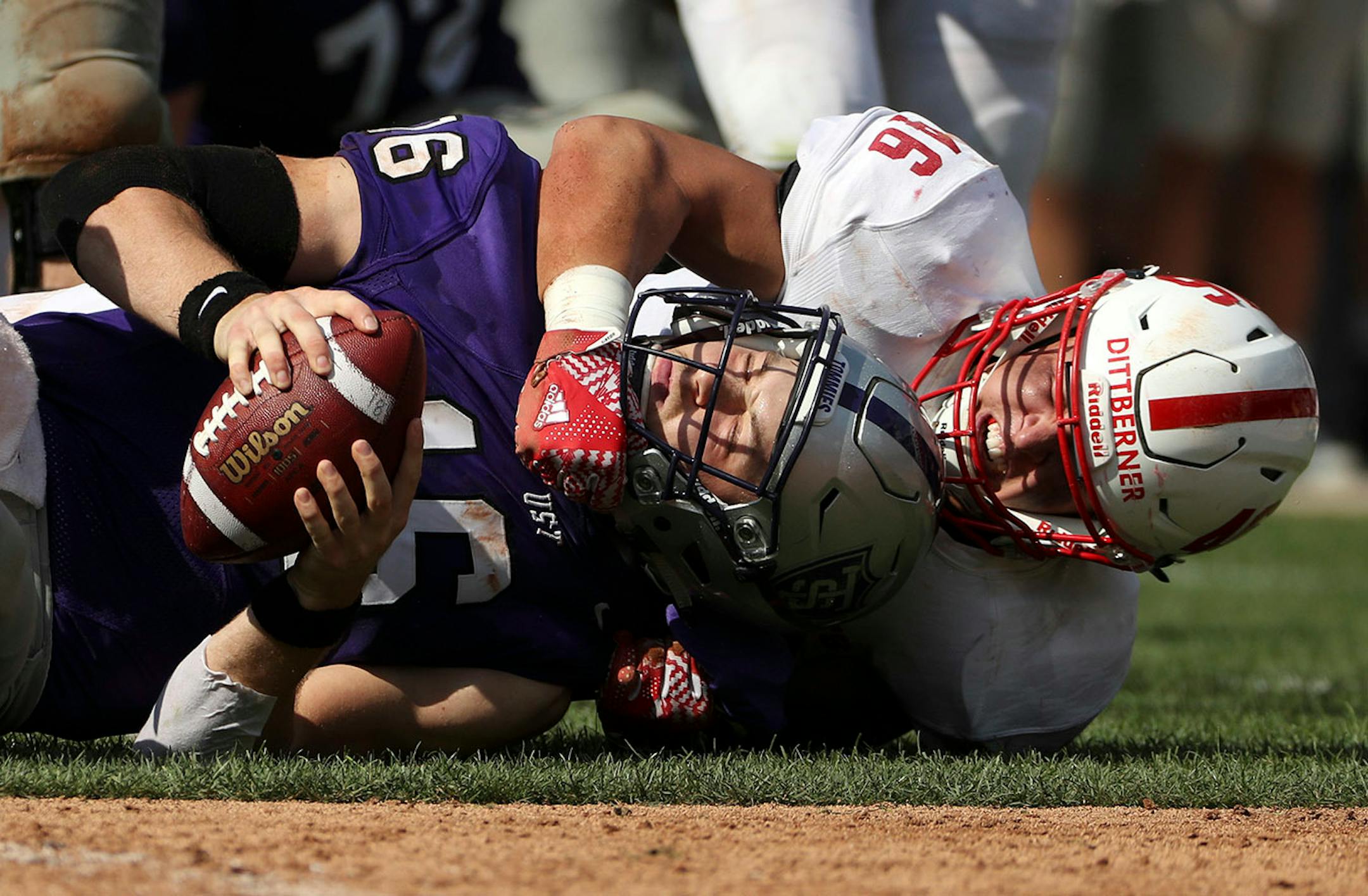 University of St. Thomas quarterback Jacques Perra (16) was sacked by St. John's University defensive lineman Trevor Dittberner (46) in the first half.