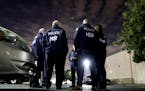 FILE - In this Jan. 10, 2018, file photo U.S. Immigration and Customs Enforcement agents gather before serving a employment audit notice at a 7-Eleven