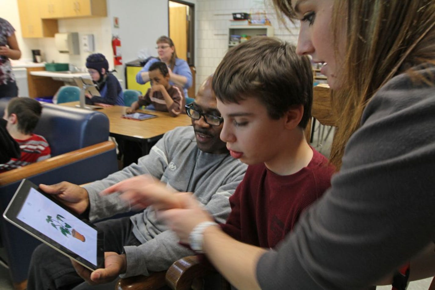 (left to right) Perry Graham, Special Education Para, student Micah Simbeck and Katy Bursaw, Special Education Para worked on the IPad during a class for developmentally disabled students at Northdale Middle School in Coon Rapids on 11/14/12.