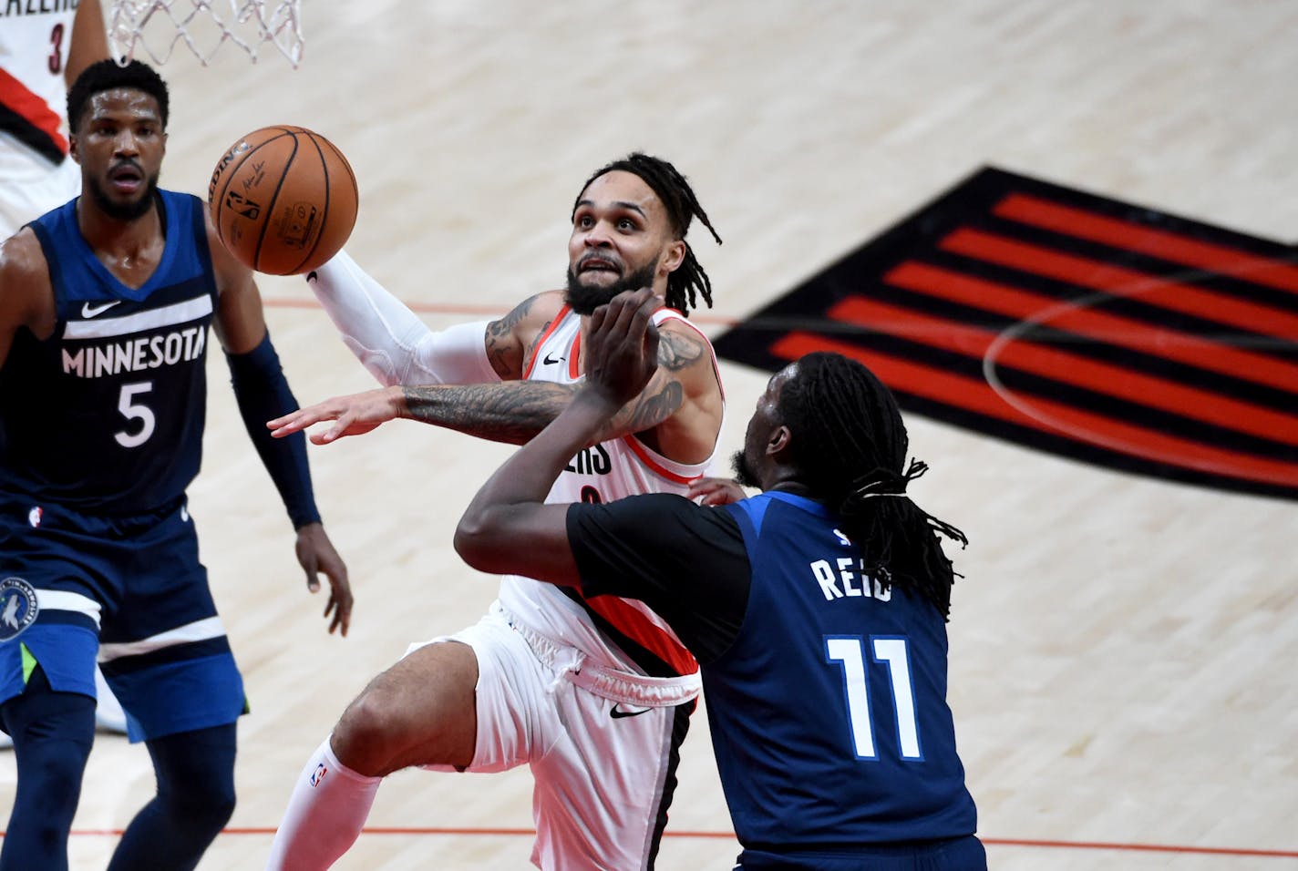 Portland Trail Blazers guard Gary Trent Jr., left, drives to the basket against Timberwolves center Naz Reid