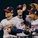 Minnesota Twins' Eduardo Escobar, right, celebrates with Brian Dozier, center, and Sam Fuld after a 1-0 win over the Cleveland Indians in a baseball g