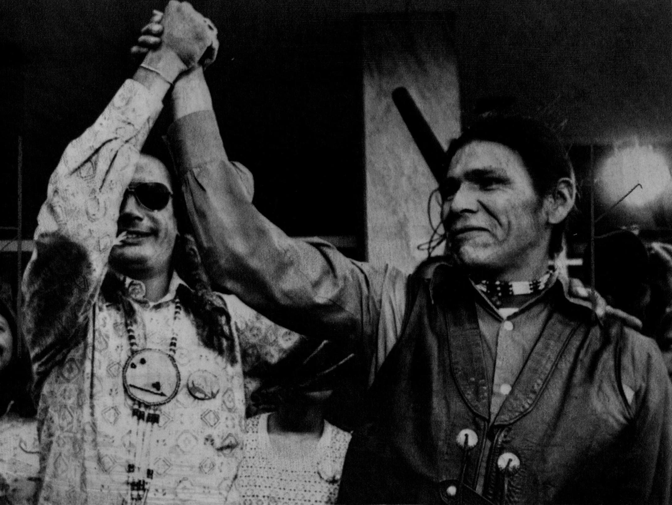 Sept.16, 1974: American Indian Movement (AIM) leaders Russell Means, left, and Dennis Banks raise hands in a victory gesture after a federal judge dismissed all charges against them. Banks and Means were charged with five felonies each in last year's 71 - day armed occupation of Wounded Knee on South Dakota' Pine Ridge Indian reservation.