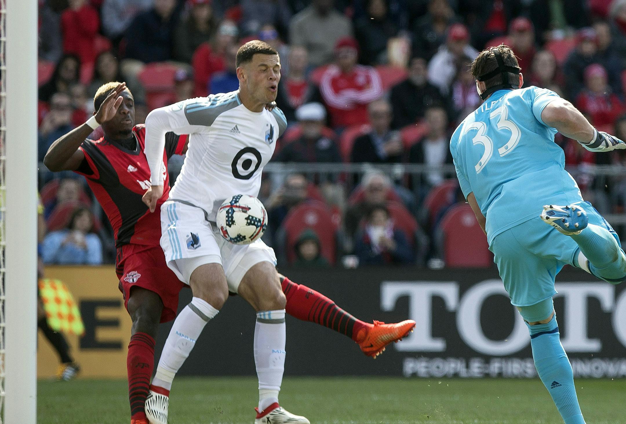 Minnesota United FCs Christian Ramirez, center, scores an own goal under pressure from Toronto FC's Chris Mavinga, left, after Minnesota United goalkeeper Bobby Shuttleworth (33) failed to deal with a cross during the second half of an MLS game in Toronto on Saturday, May 13, 2017. (Chris Young/The Canadian Press via AP)