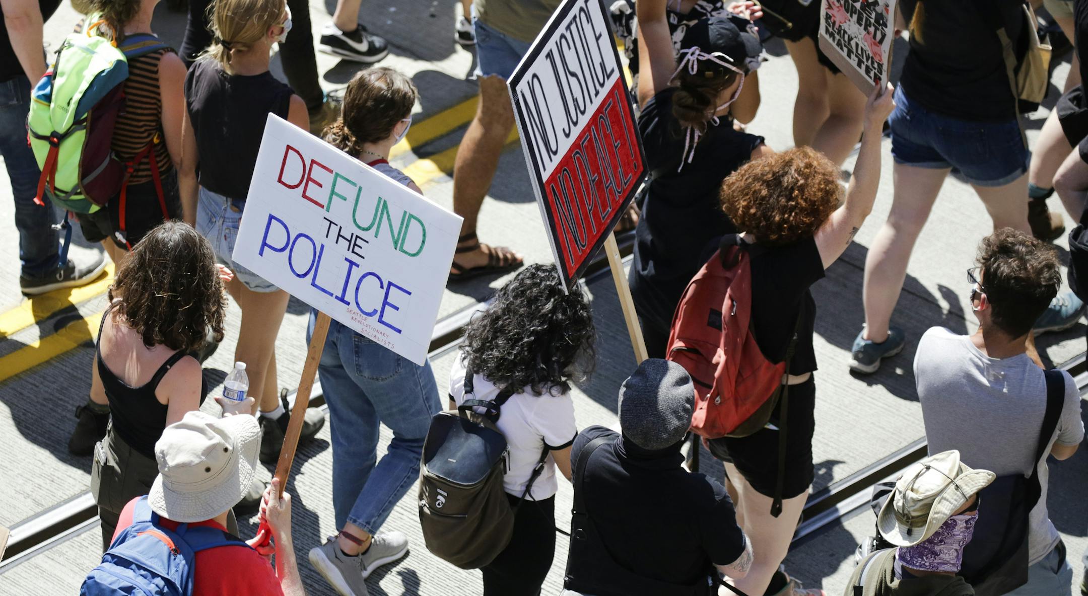 People carry signs during a "Defund the Police" march from King County Youth Jail to City Hall in Seattle, Washington on August 5, 2020. (Jason Redmond/AFP via Getty Images/TNS) ORG XMIT: 1803621