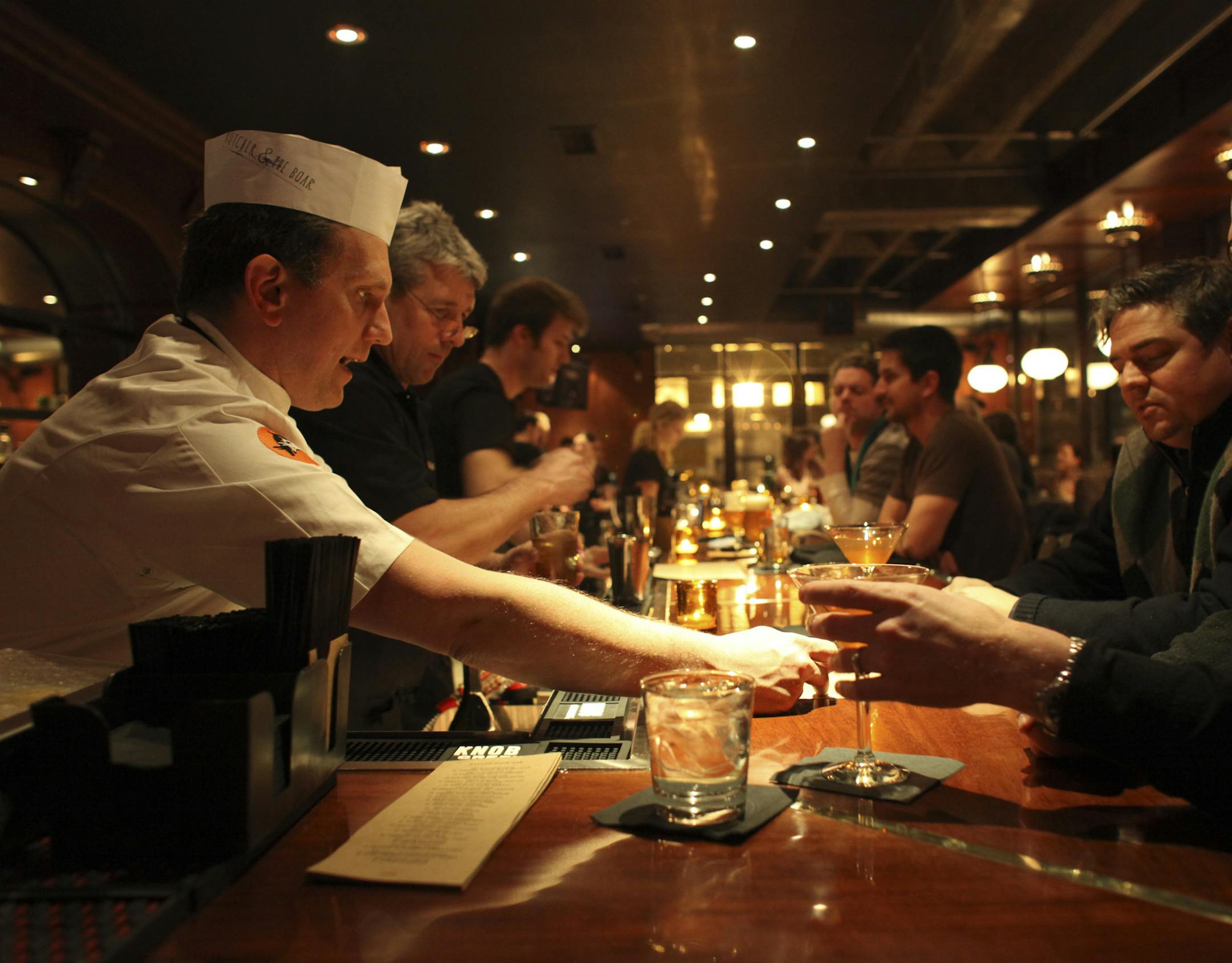 Head chef Jack Riebel, left, gave Chad Murphy, far, and Kevin Fraley some suggestions on the menu during the soft opening of Butcher & the Boar in Minneapolis Min., Saturday, March 3, 2012. ] (KYNDELL HARKNESS/STAR TRIBUNE) kyndell.harkness@startribune.com ORG XMIT: MIN2012122614503482