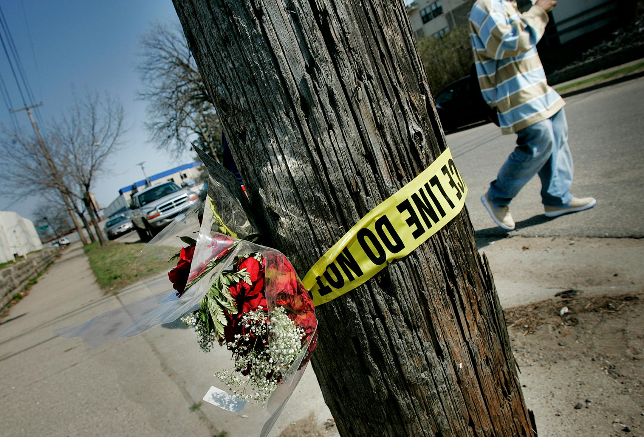 Police tape and a bouquet of roses were taped to a telephone pole in an alley near where Richard Christianson and Michal Trinity were murdered execution style last April. The man accused of killing them, Dontaro Riddley, 20, is on trial.