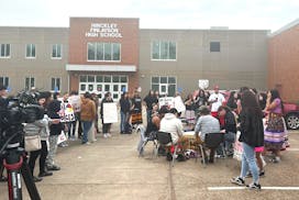 About 100 students and community members gathered outside the Hinckley-Finlayson High School Wednesday afternoon to sing and drum in protest of a scho