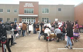 About 100 students and community members gathered outside the Hinckley-Finlayson High School Wednesday afternoon to sing and drum in protest of a scho