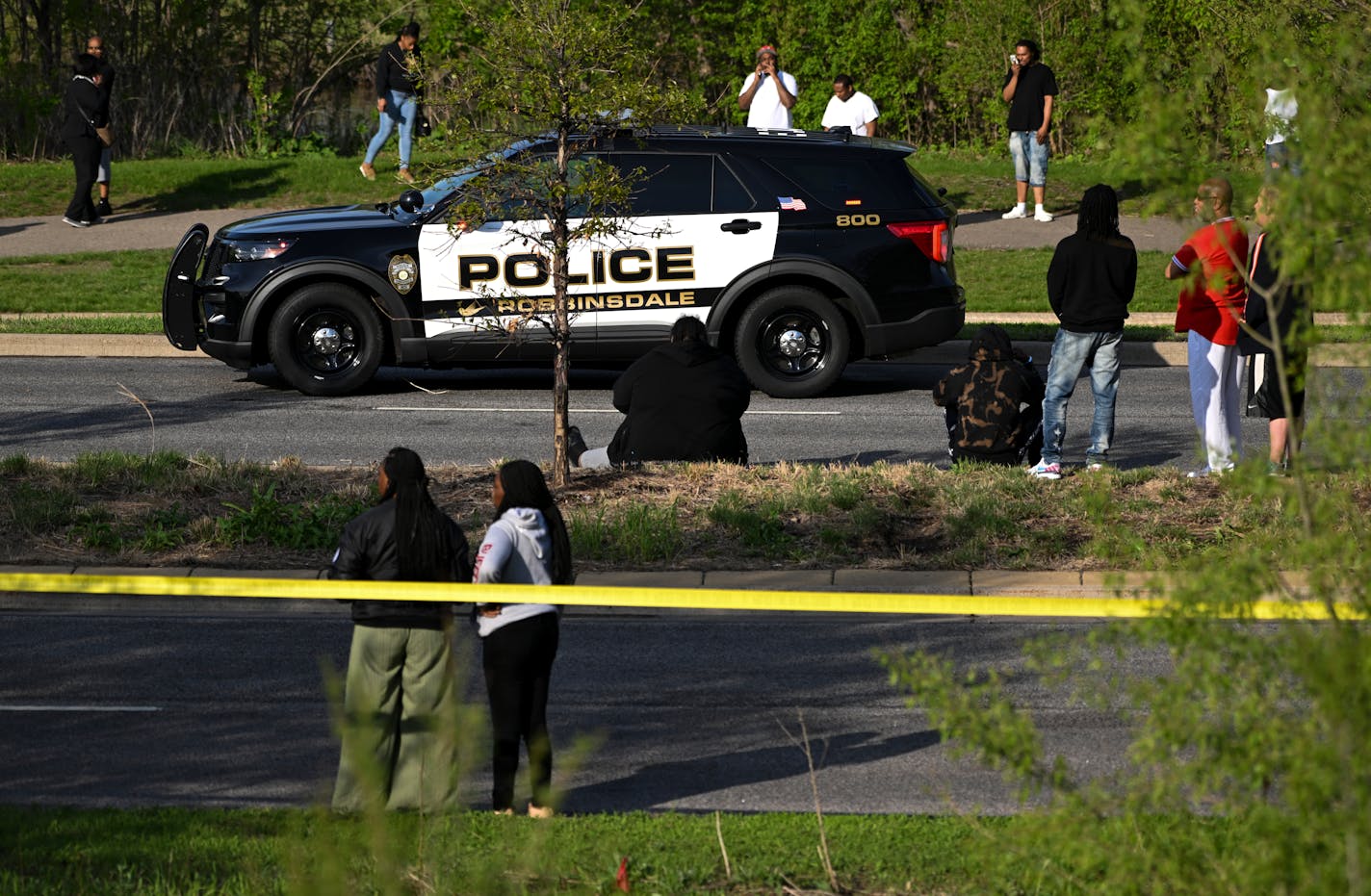 A crowd gathered near the scene of a fatal shooting in Robbinsdale on County Road 81 near Crystal Lake Thursday, May 19, 2022 in Robbinsdale, Minn. ] Aaron Lavinsky • aaron.lavinsky@startribune.com