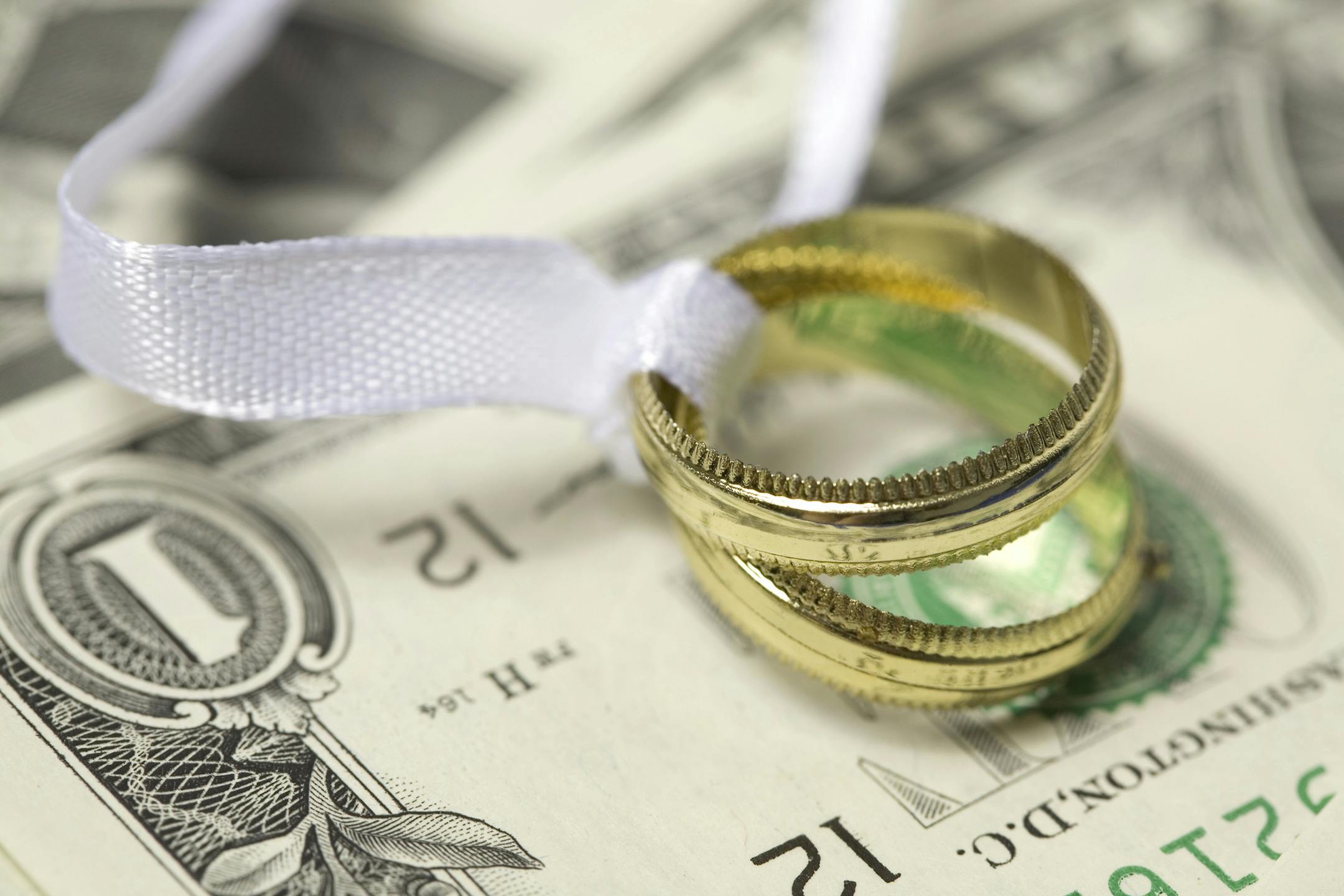 Wedding rings on cash marriage money finance istockphoto.com