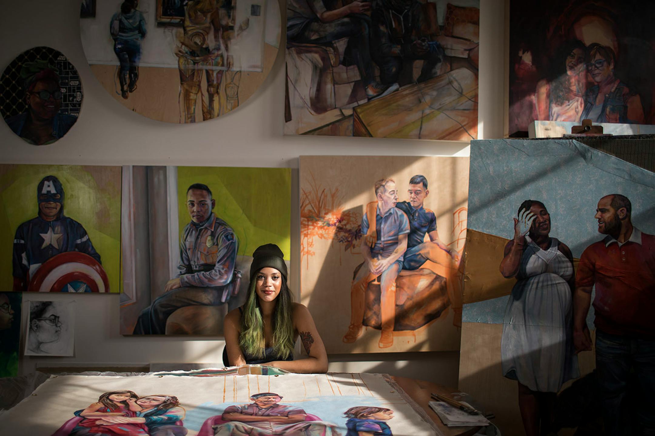 Artist Leslie Barlow poses for a photo in her studio with some of her paintings.