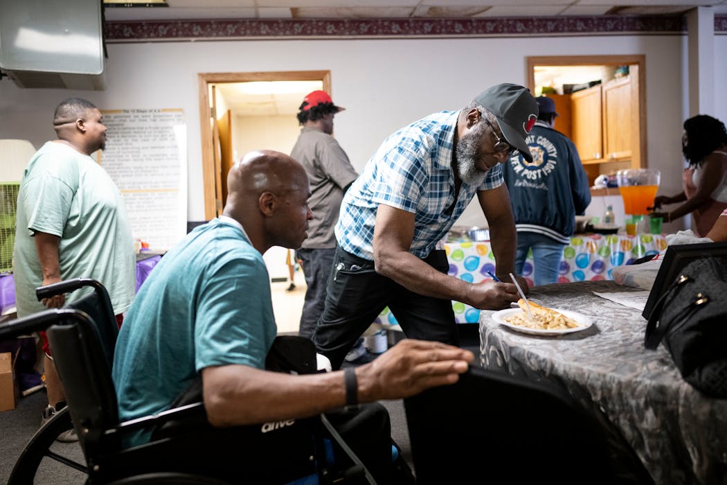 James Page, center, gave his contact information to a new support group member at Grace Temple Church in Minneapolis.