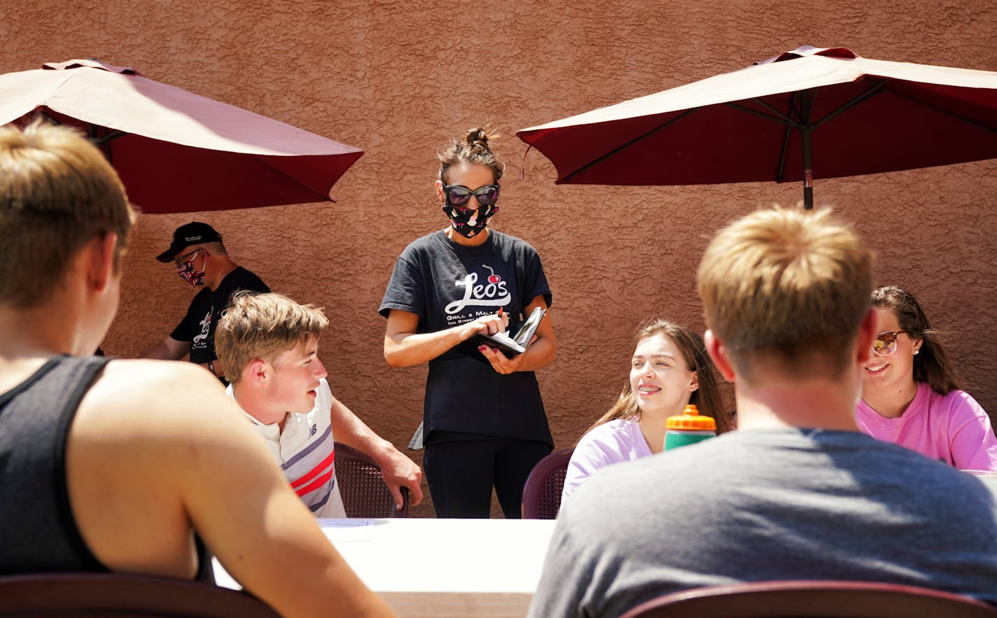 Angie Burger took orders and delivered drinks to customers in the restaurant's outdoor seating. Monday was the first day Minnesota restaurants were allowed to serve customers outdoors.