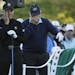 Jack Nicklaus and Gary Player wipe tears from their eyes as a chair is draped with a green jacket to honor Arnold Palmer before the start of the first