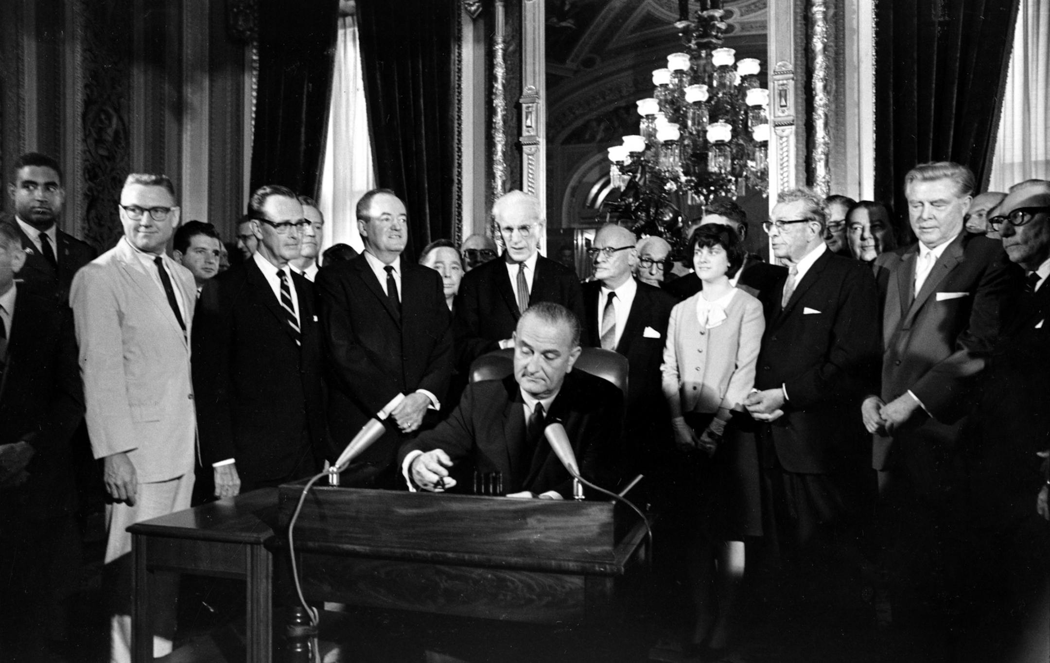 U.S. President Lyndon B. Johnson signs the Voting Rights Act of 1965 in a ceremony in the President's Room near the Senate chambers in Washington, D.C., Aug. 6, 1965. Surrounding the president from left directly above his right hand, Vice President Hubert Humphrey; Speaker John McCormack; Rep. Emanuel Celler, D-N.Y.; first daughter Luci Johnson; and Sen. Everett Dirkson, R-Ill. Behind Humphrey is House Majority Leader Carl Albert of Oklahoma; and behind Celler is Sen. Carl Hayden, D-Ariz. (AP Ph