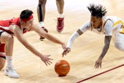 Nebraska's Keisei Tominaga (10) and the Gophers' Elijah Hawkins (0) fought for a loose ball in the second half Dec. 6, 2023, at Williams Arena.