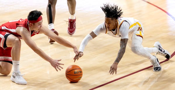 Nebraska's Keisei Tominaga (10) and the Gophers' Elijah Hawkins (0) fought for a loose ball in the second half Dec. 6, 2023, at Williams Arena.