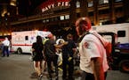 Paramedics transport a person from the scene where three people were stabbed during an altercation outside Navy Pier after a Fourth of July fireworks 