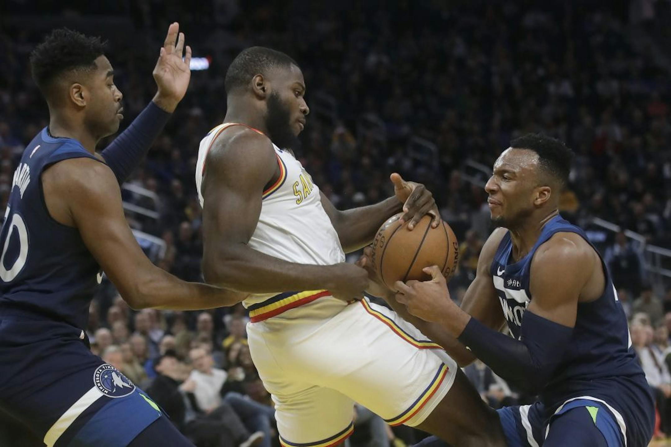 Minnesota Timberwolves guard Josh Okogie, right, takes the ball from Golden State Warriors forward Eric Paschall, center, during the second half of an NBA basketball game in San Francisco, Monday, Dec. 23, 2019. At left is Timberwolves forward Kelan Martin.