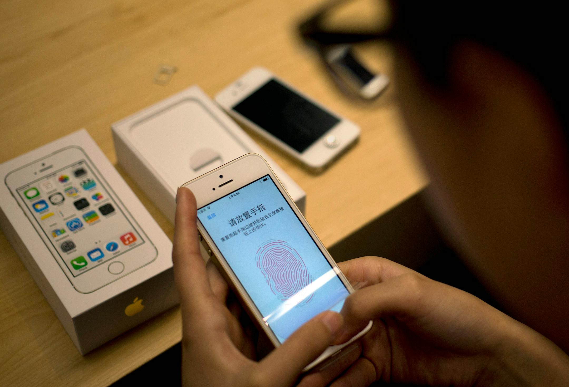 A customer configures the fingerprint scanner technology built into iPhone 5S at an Apple store in Wangfujing shopping district in Beijing on Friday, Sept. 20, 2013. Apple released the iPhone 5S and 5C models on Friday.