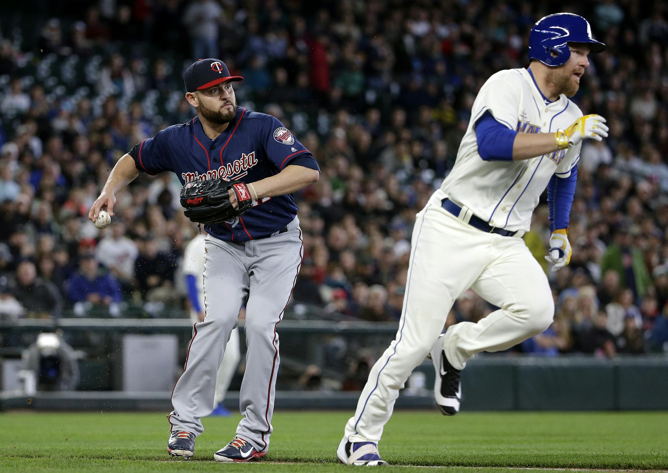 Minnesota Twins starting pitcher Ricky Nolasco, left, readies a throw to first after fielding a ground ball by Seattle Mariners' Adam Lind, right, in the second inning of a baseball game Sunday, May 29, 2016, in Seattle. Lind was out on the play. (AP Photo/Elaine Thompson)