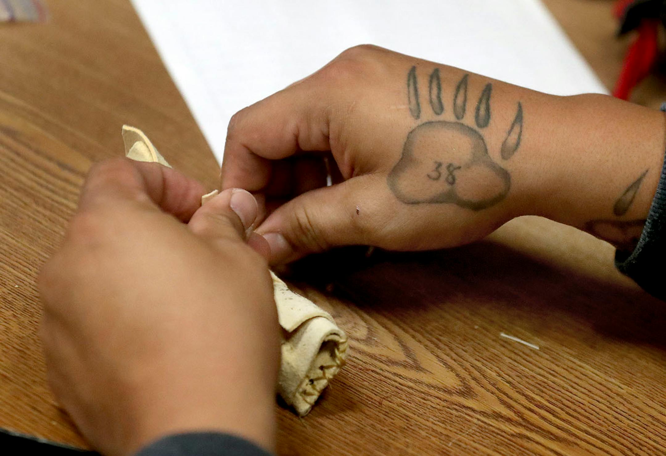 Mat Pendleton, Lower Sioux Community leader, ties a tobacco pouch made with deer hide at the community center.