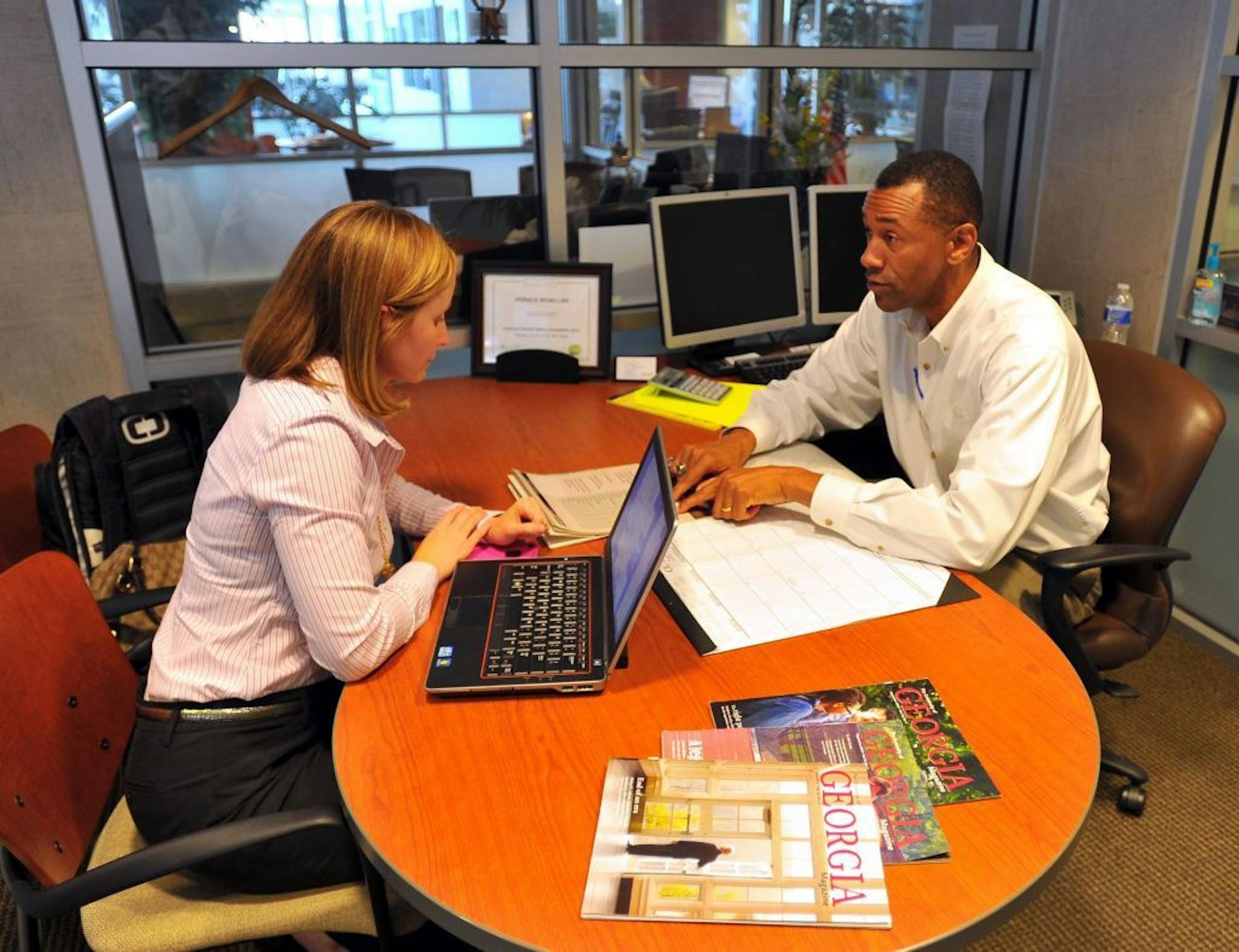 Lexus salesman Horace McMillan, right, reviews warranty information with car buyer Jennifer Williams at a dealership in Smyrna, Georgia, on October 1, 2013.