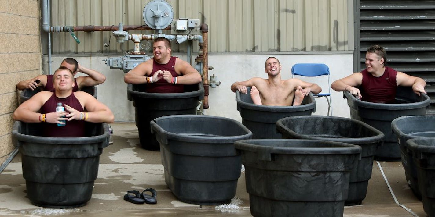 From left, Gophers football players Ed Olson (foreground), Grayson Levine, Tommy Olson, Jordan Wettstein and Ernie Heifort chilled their weary muscles in tubs of ice water after a recent morning practice at the Bierman football complex. A well-coordinated support staff makes sure two-a-day practices, and the many details they entail, go smoothly.