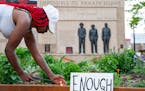 Quita Leach lit candles in front of the Clayton Jackson McGhie Memorial on June 3 in Duluth, MN. ]