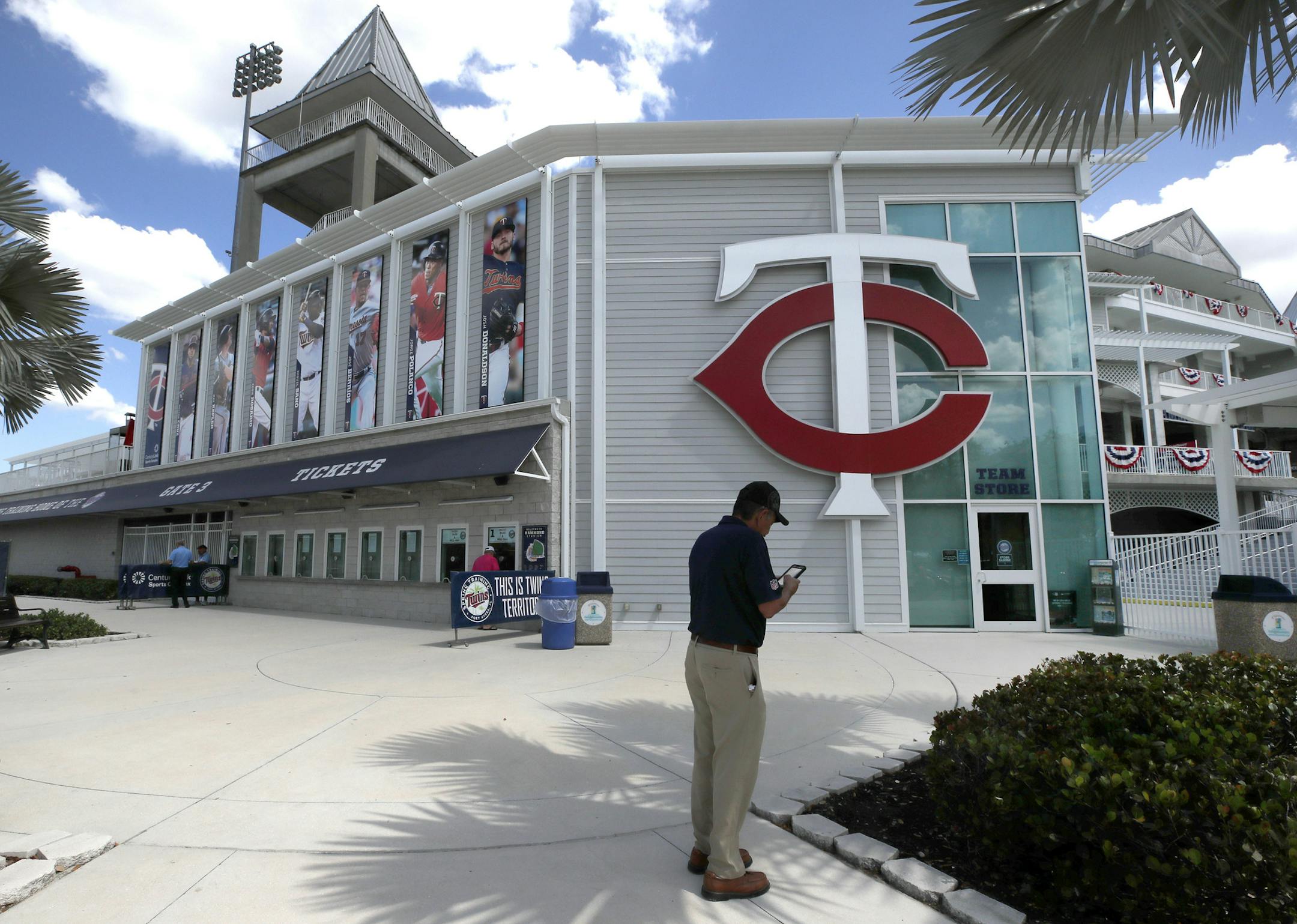 Twins fan Bill Gallegos, of Los Angeles, Calif., checks his phone after taking pictures outside a closed Hammond Stadium in March.