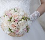 Cream wedding bouquet of roses and freesias in the hands of the bride. istock photo